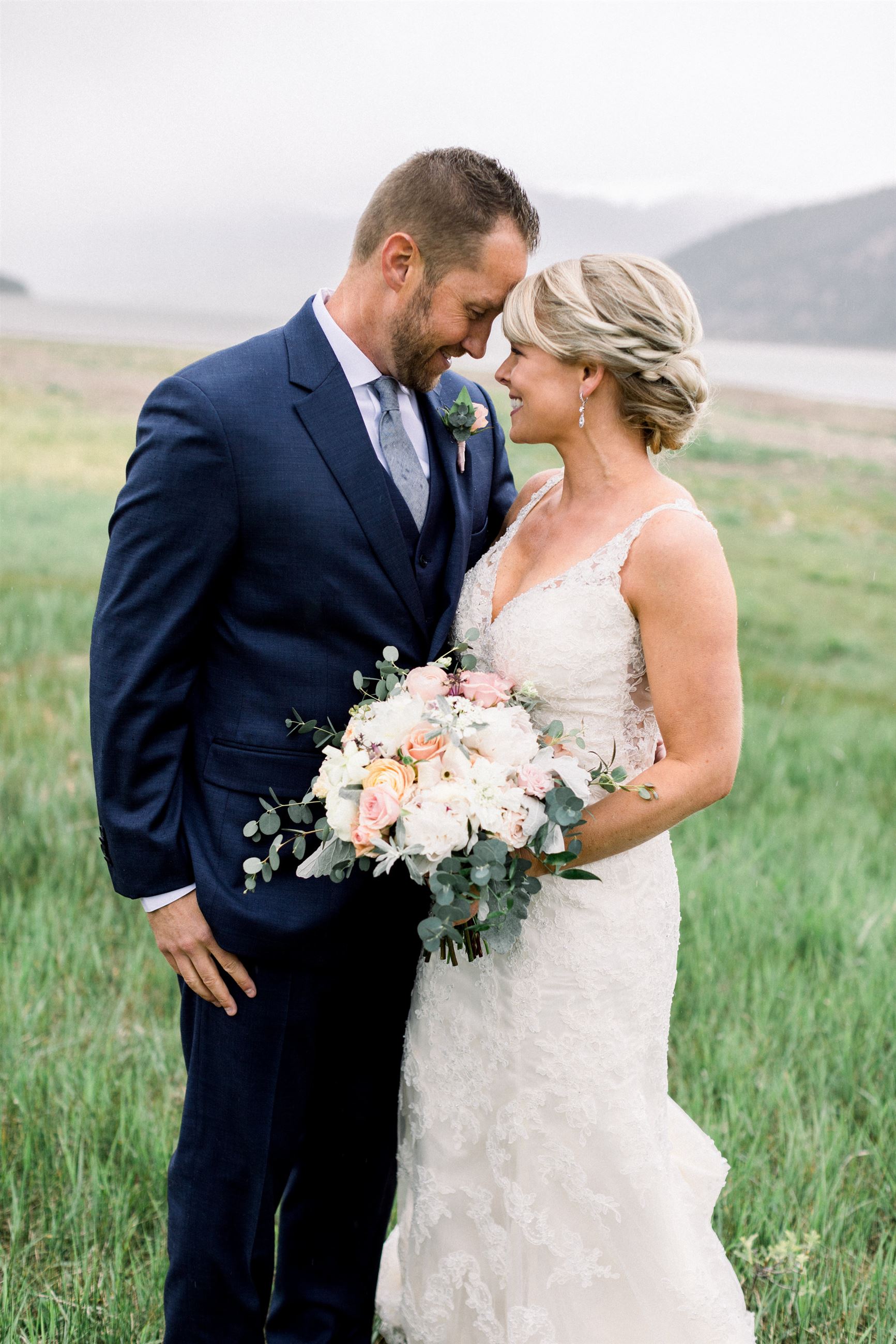 bride and groom staring at one another in grass field