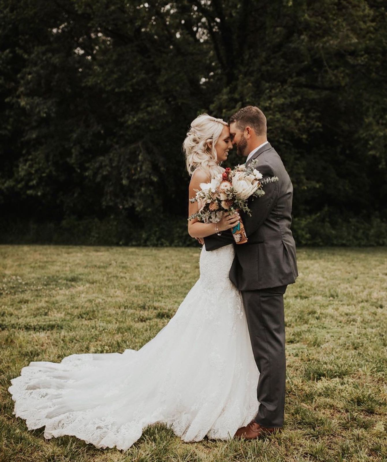 Bride and Groom staring into each other's eyes in field