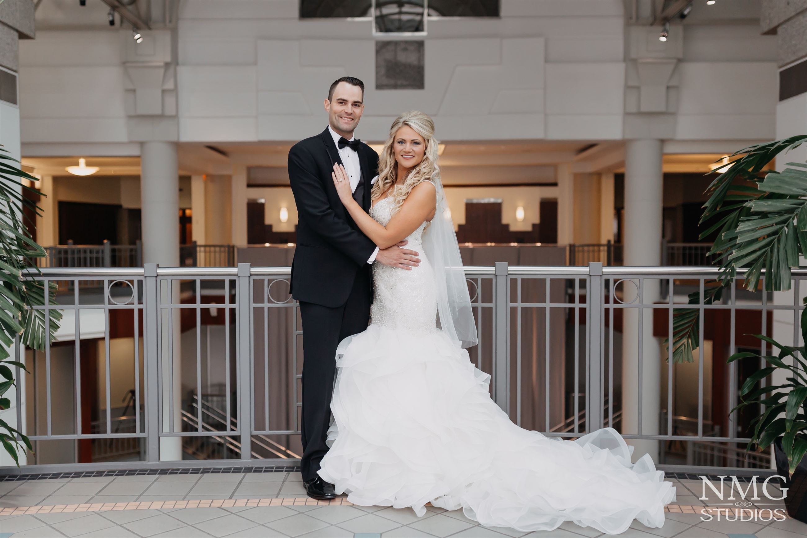 bride and groom in front of a railing