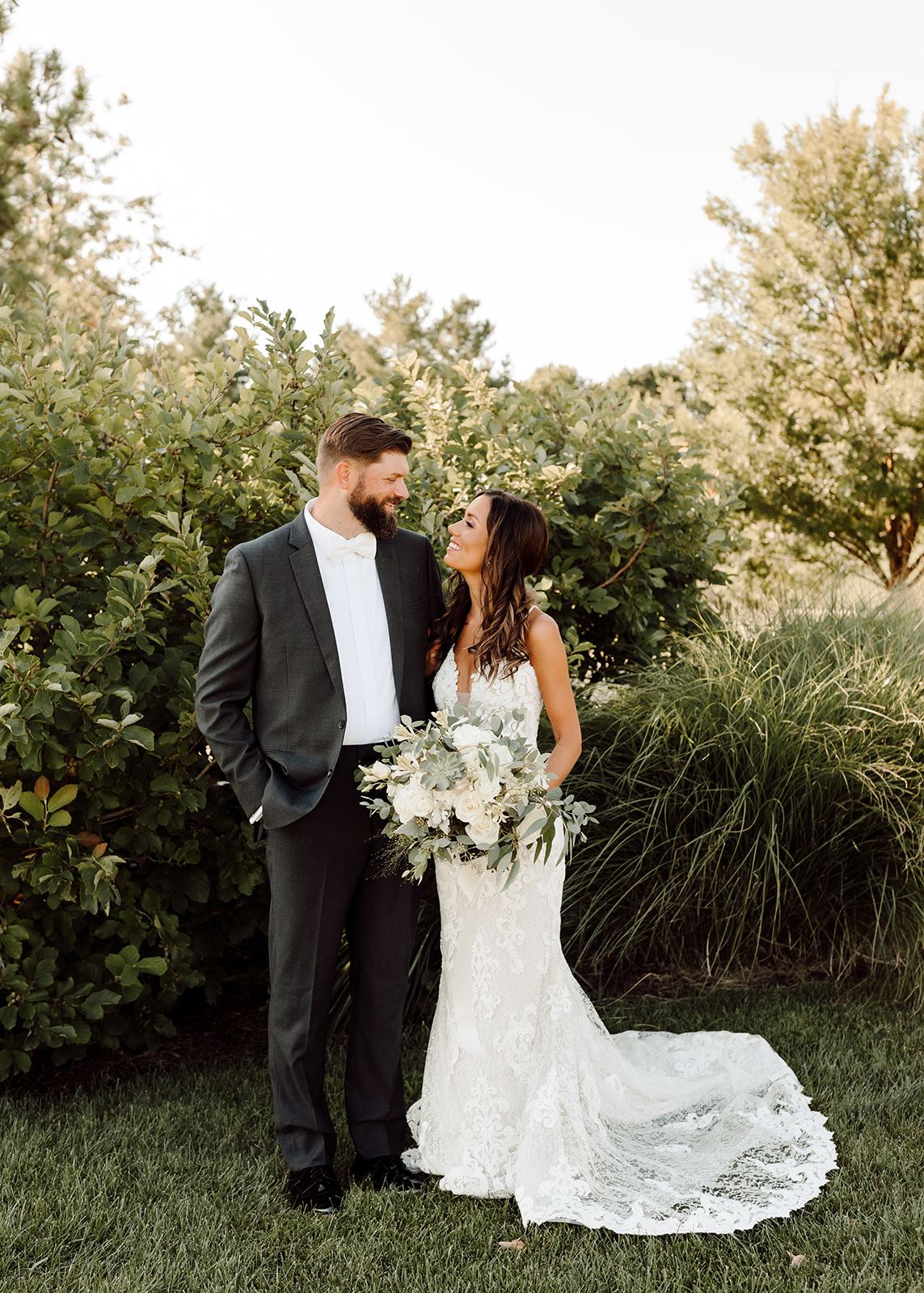 Bride and Groom In Front Of Greenery.