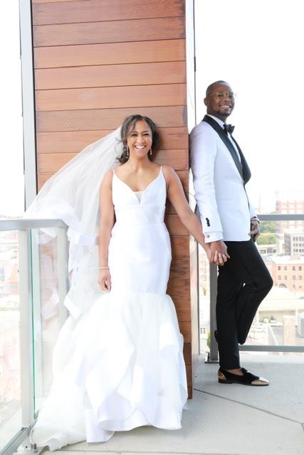 Bride And Groom Standing On Either Side Of A Wall